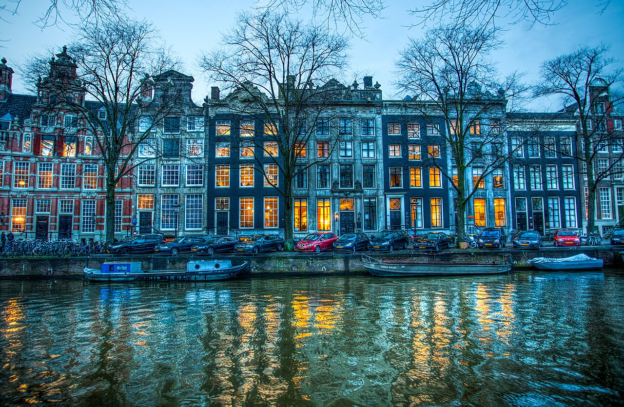 Lit canal houses along the Herengracht at dusk
